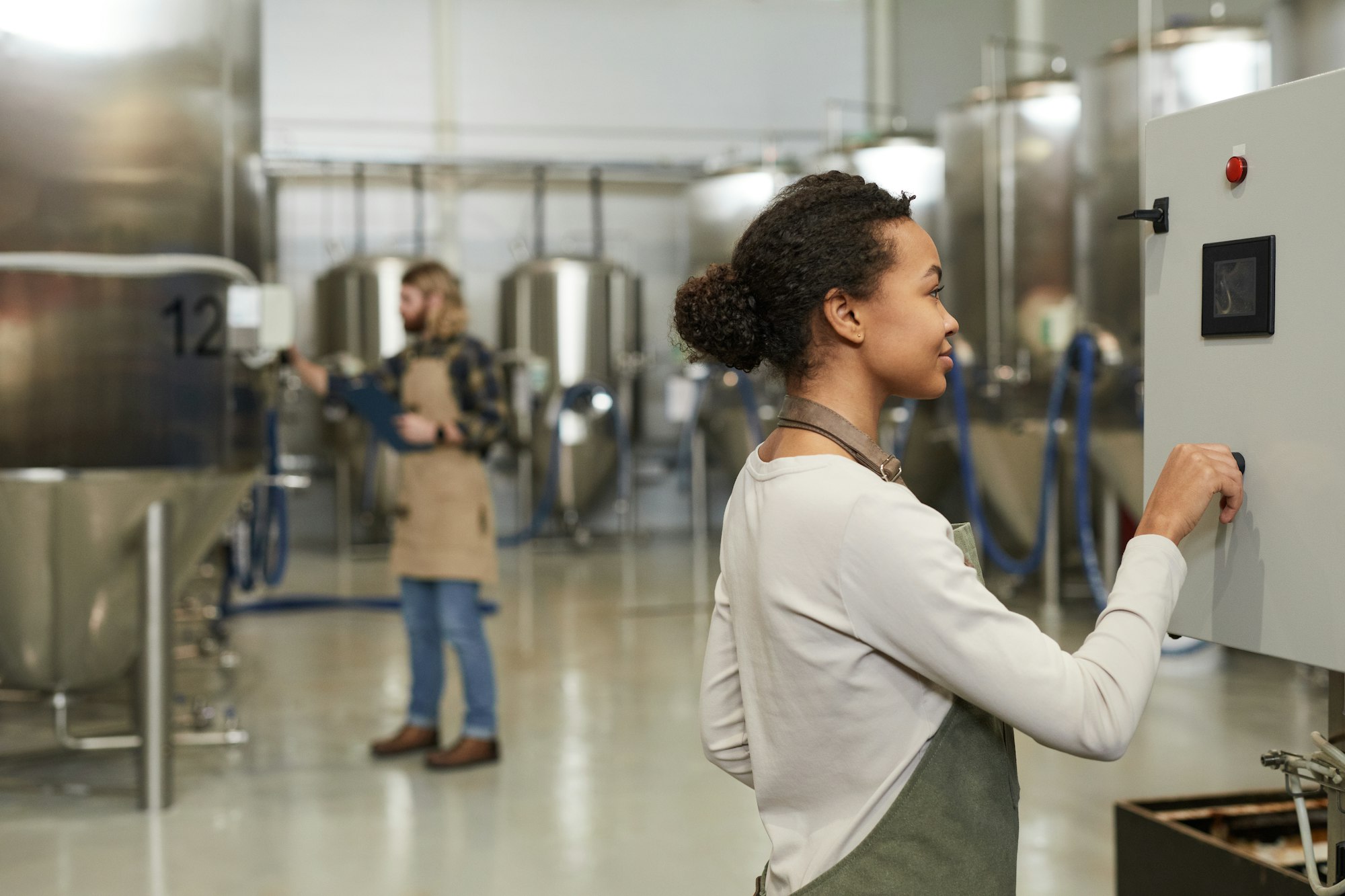 Young Woman Starting Machines at Brewery